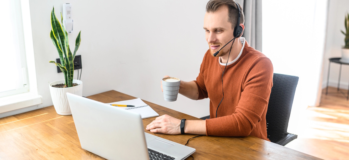 Mann arbeitet mit Headset am Laptop im Homeoffice und führt Kundengespräch – Beispiel für Vertrieb nebenberuflich im Online-Business