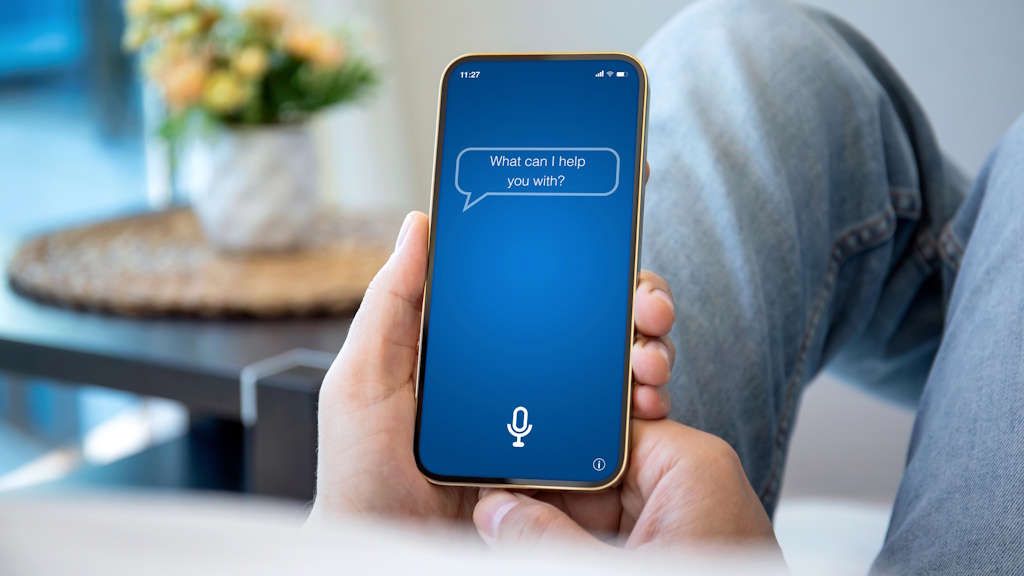 So bekommen Unternehmen die unregulierte KI-Nutzung in den Griff_TB Person nutzt einen KI-Assistenten auf dem Smartphone als Beispiel für unregulierte KI-Nutzung im Arbeitsalltag.
